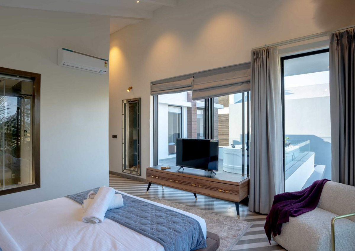 Spacious bedroom featuring large windows and modern TV setup