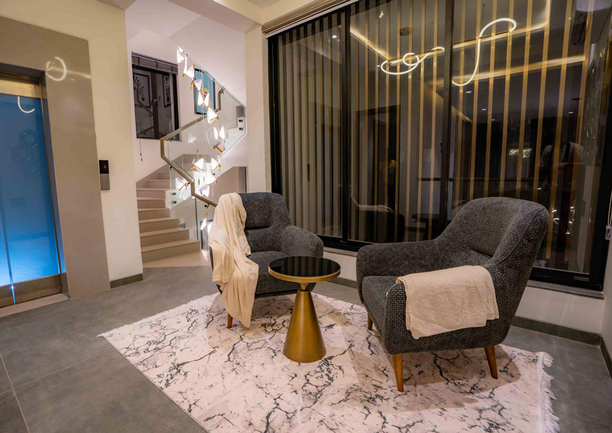 Comfortable indoor seating area near staircase with accent chairs and rug